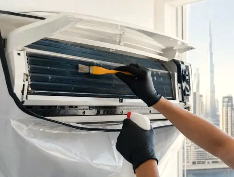 Technician deep-cleaning the indoor unit of a split AC
